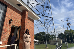 WVAS News Director Melanie Hogan (right) and Marketing Administrative Coordinator Jamillah Bell standing outside WVAS studio with radio tower in background